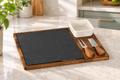Acacia cheese board set with white ceramic bowl, slate serving section and stainless steel cheese cutlery.